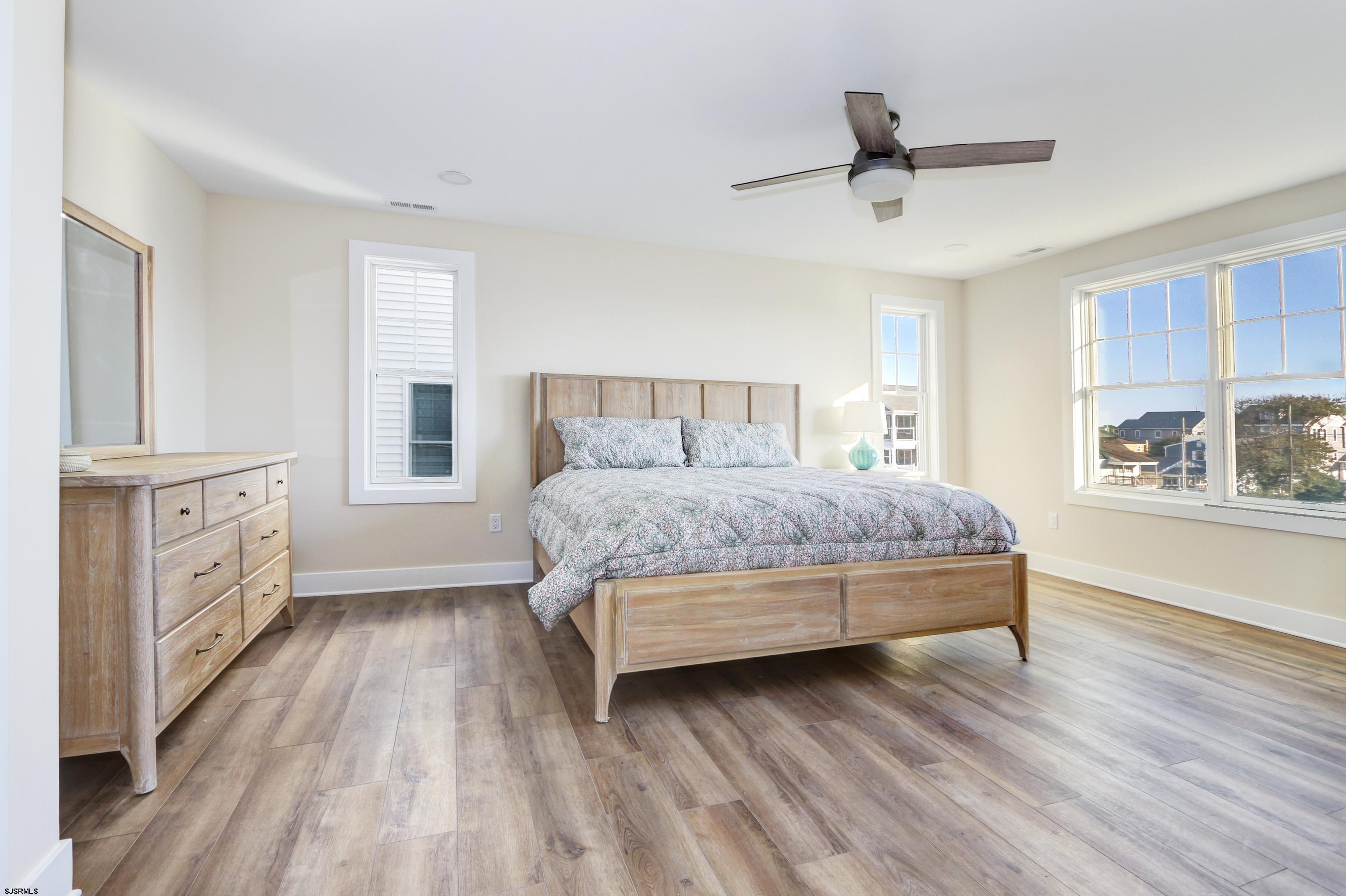 303 Lafayette Place Brigantine, NJ 08203 - Photo 17 of 38 a bedroom with a bed and a dresser next to a window