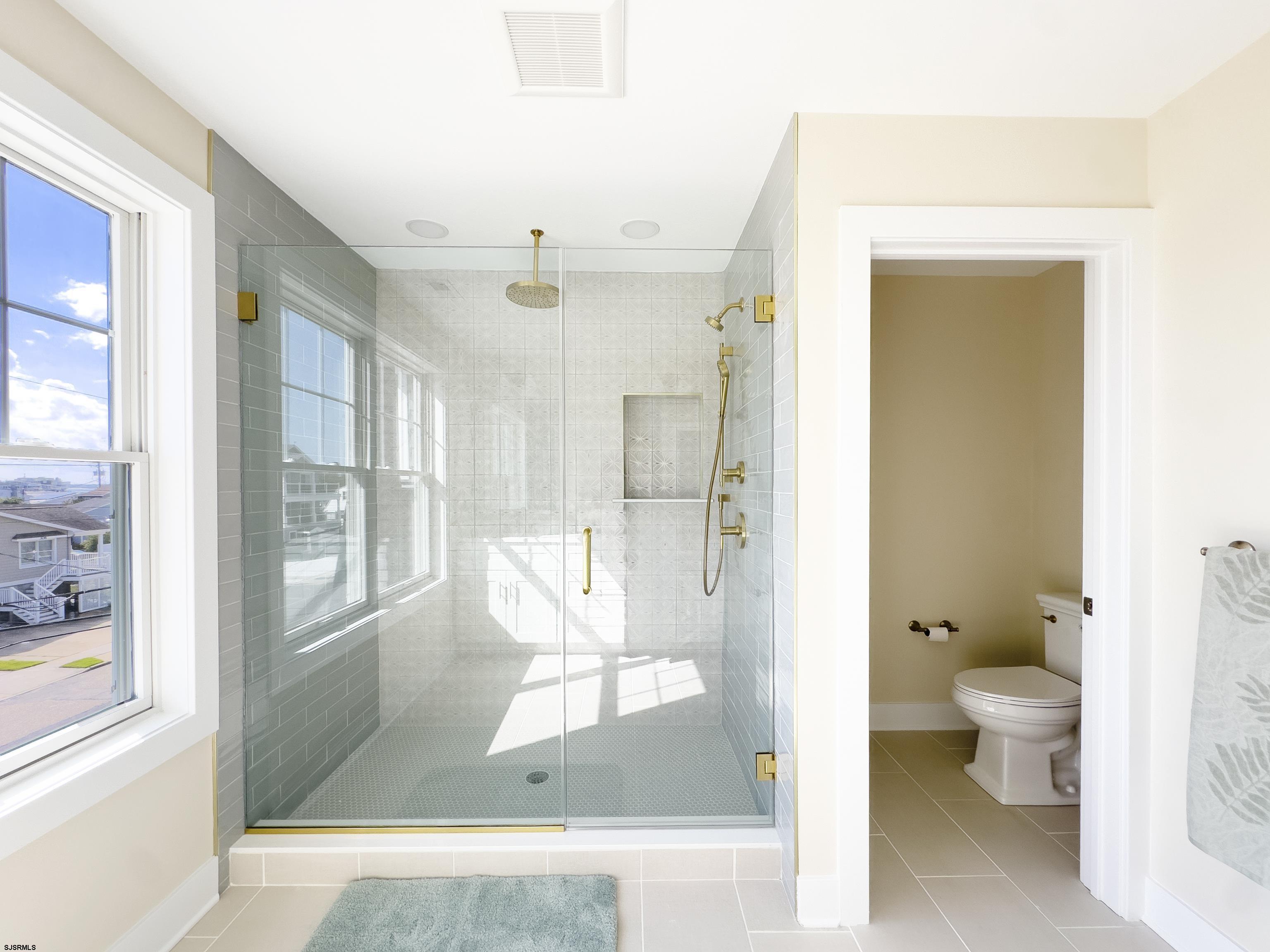 303 Lafayette Place Brigantine, NJ 08203 - Photo 20 of 38 a bathroom with a glass shower door and a toilet