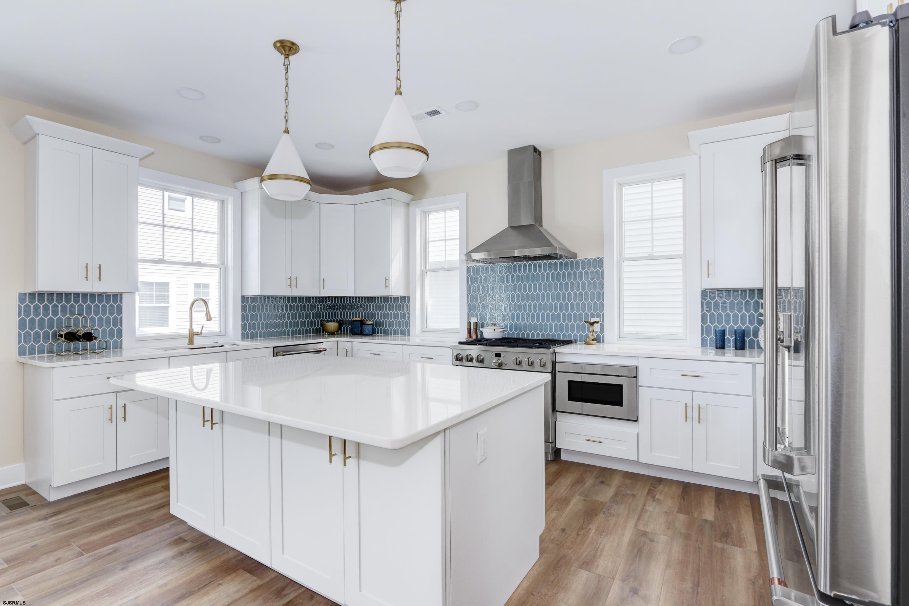 303 Lafayette Place Brigantine, NJ 08203 - Photo 2 of 38 a kitchen with a stove a sink a center island and a window