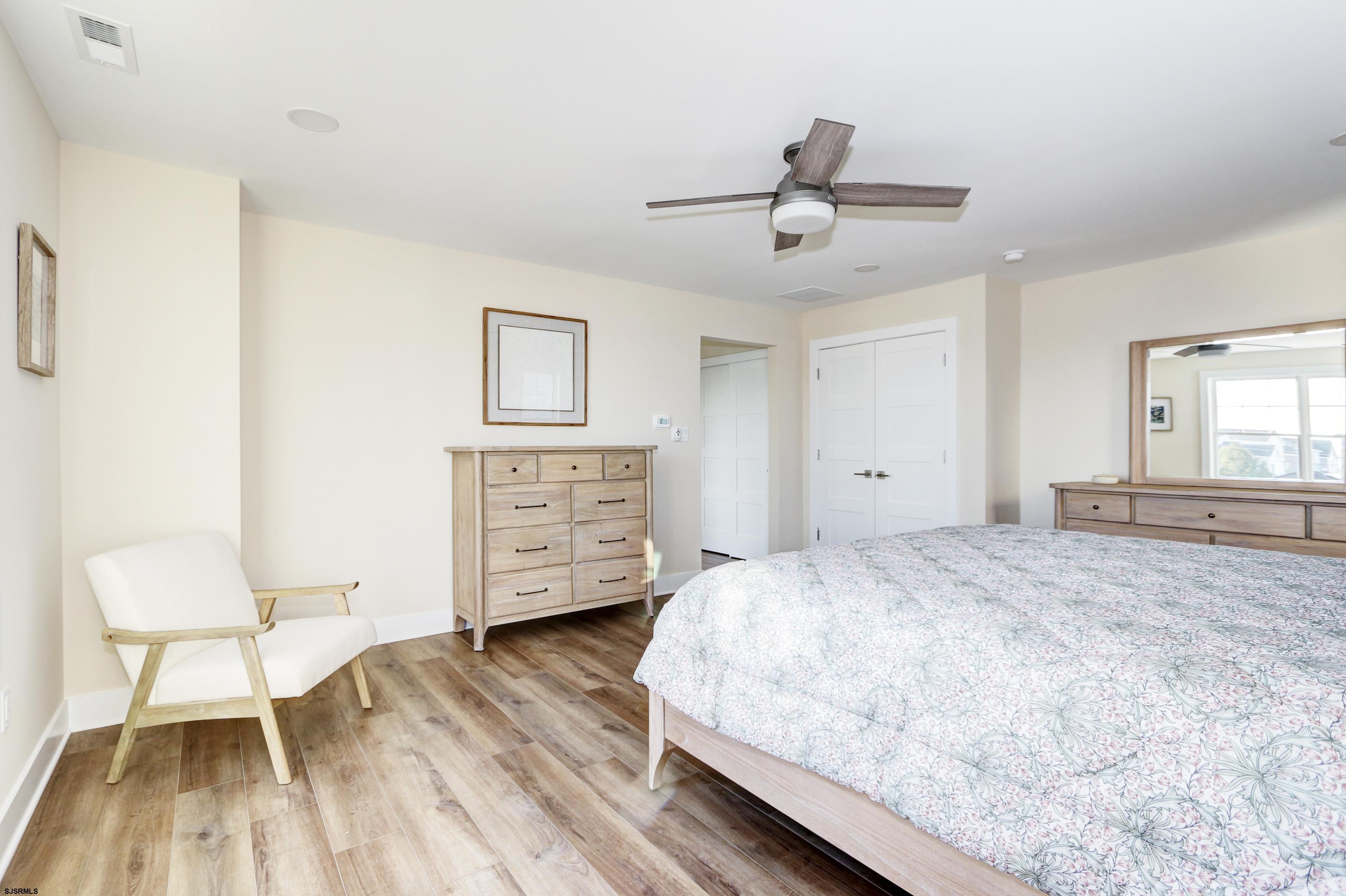 303 Lafayette Place Brigantine, NJ 08203 - Photo 24 of 38 a spacious bedroom with a bed and a chair