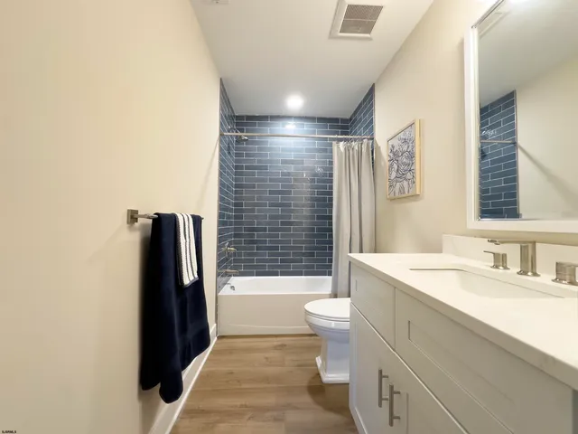 a bedroom with a bed and a flat tv screen on dresser
