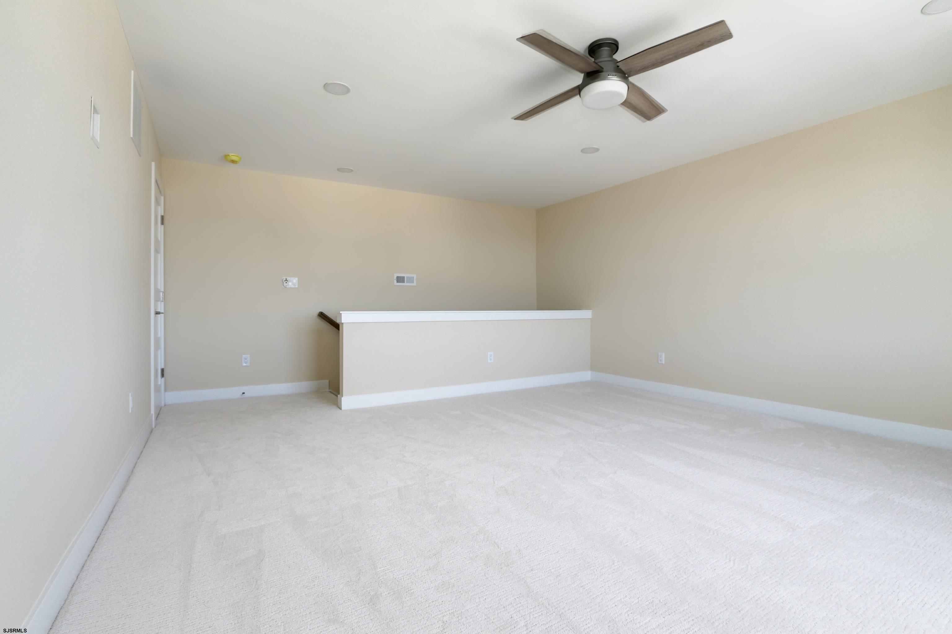 303 Lafayette Place Brigantine, NJ 08203 - Photo 34 of 38 an empty room with a ceiling fan and carpet