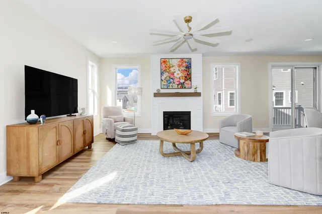 a living room with furniture a flat screen tv and a fireplace