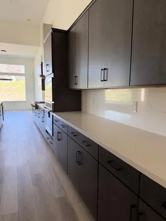 a kitchen with stainless steel appliances a sink dishwasher stove refrigerator and cabinets