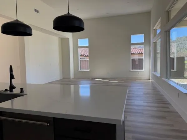 a kitchen with stainless steel appliances a table chairs in it and wooden floor