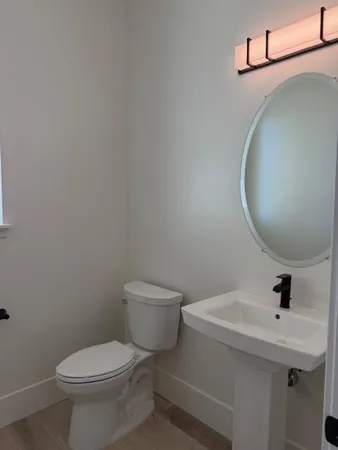 a bathroom with a toilet sink and mirror
