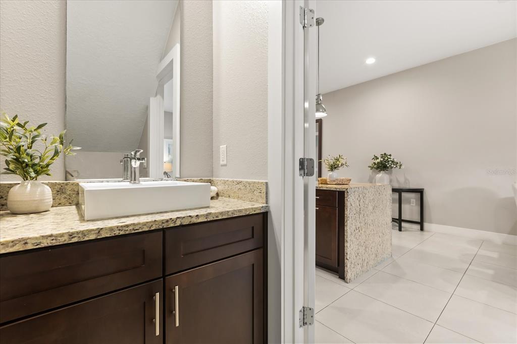 2637 Sunrise Shores Drive Kissimmee, FL 34747 - Photo 14 of 39 a bathroom with a granite countertop sink and a mirror