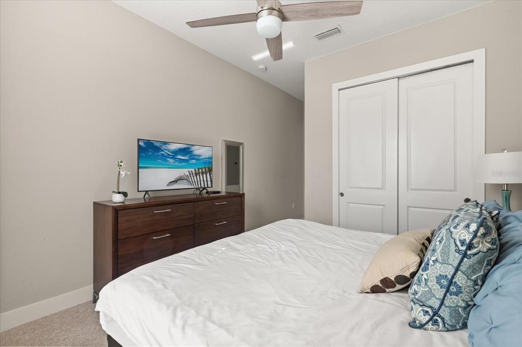 2637 Sunrise Shores Drive Kissimmee, FL 34747 - Photo 19 of 39 a bedroom with a bed and a dresser