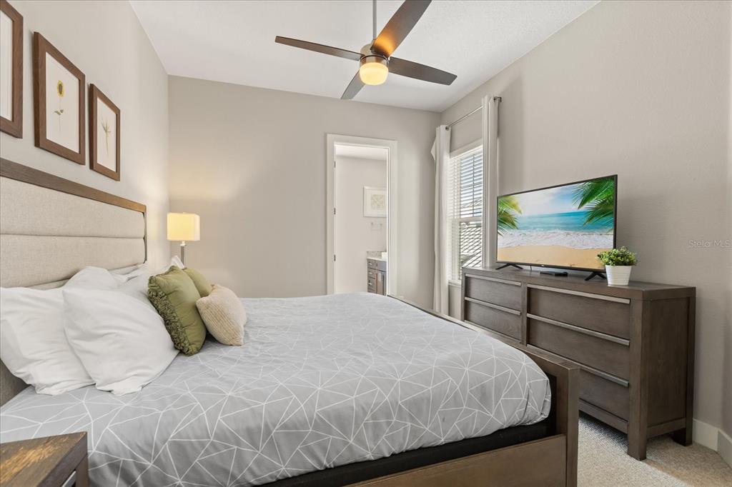 2637 Sunrise Shores Drive Kissimmee, FL 34747 - Photo 21 of 39 a bedroom with a bed and a flat screen tv