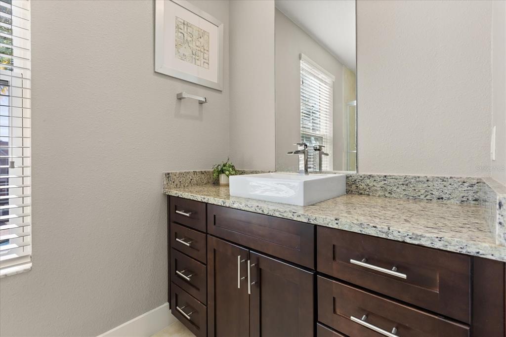 2637 Sunrise Shores Drive Kissimmee, FL 34747 - Photo 23 of 39 a bathroom with a granite countertop sink and a mirror