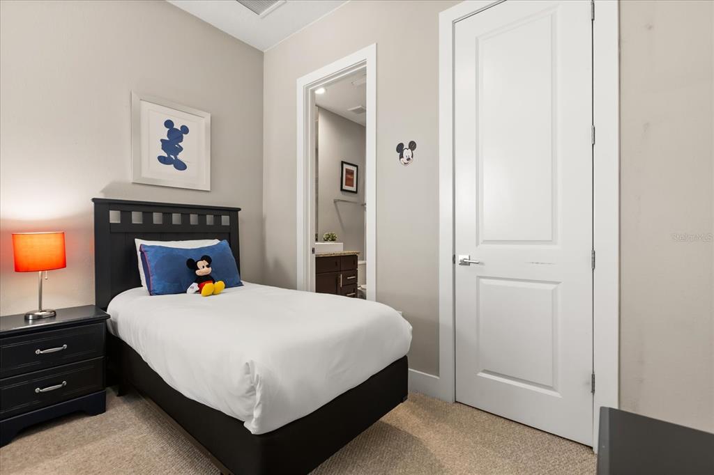 2637 Sunrise Shores Drive Kissimmee, FL 34747 - Photo 26 of 39 a bedroom with a bed and a lamp on dresser