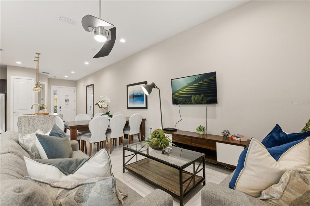 2637 Sunrise Shores Drive Kissimmee, FL 34747 - Photo 32 of 39 a living room with furniture a flat screen tv and kitchen view