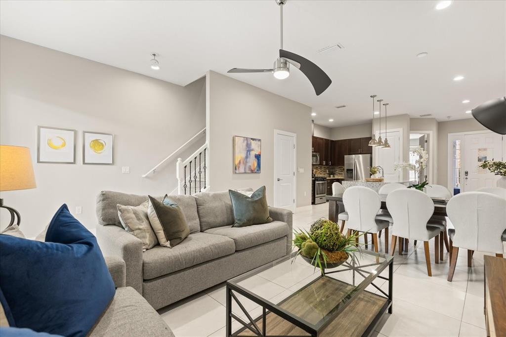 2637 Sunrise Shores Drive Kissimmee, FL 34747 - Photo 4 of 39 a living room with furniture kitchen view and a chandelier