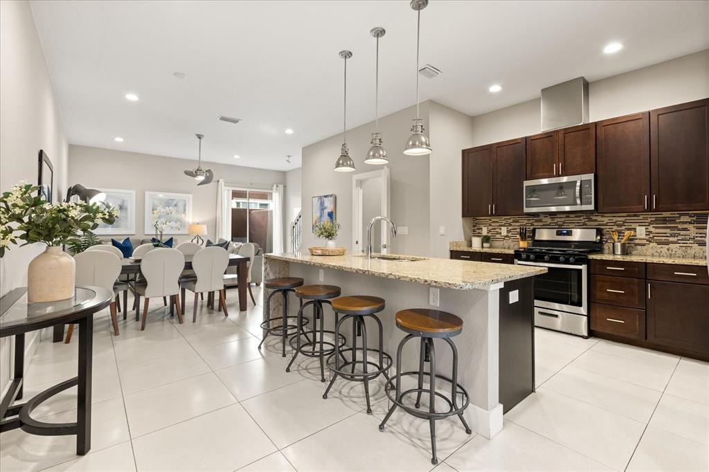 2637 Sunrise Shores Drive Kissimmee, FL 34747 - Photo 5 of 39 a large kitchen with lots of furniture a dining table and chairs