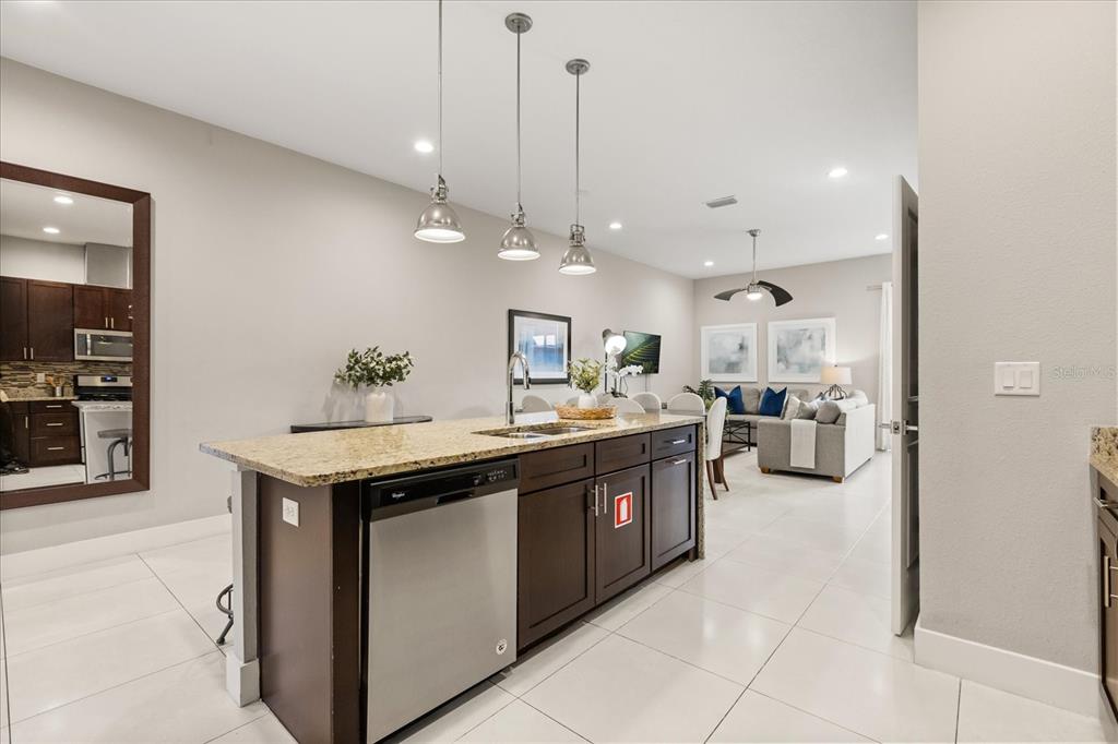 2637 Sunrise Shores Drive Kissimmee, FL 34747 - Photo 7 of 39 a large kitchen with kitchen island a sink counter top space and stainless steel appliances