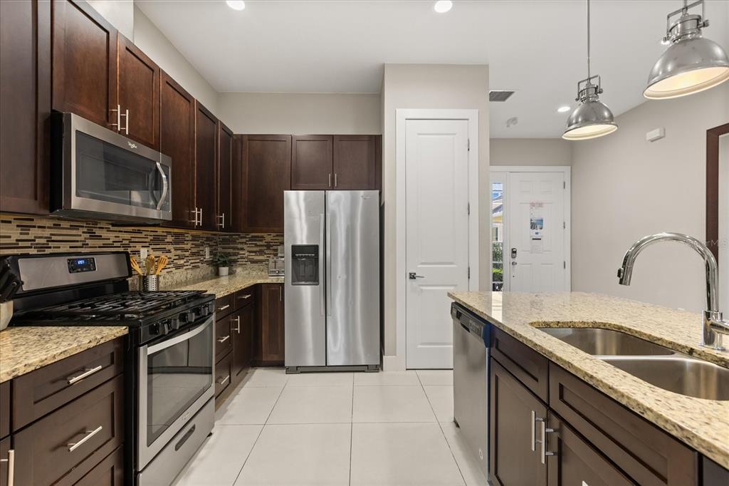 2637 Sunrise Shores Drive Kissimmee, FL 34747 - Photo 8 of 39 a kitchen with stainless steel appliances granite countertop a sink stove and refrigerator