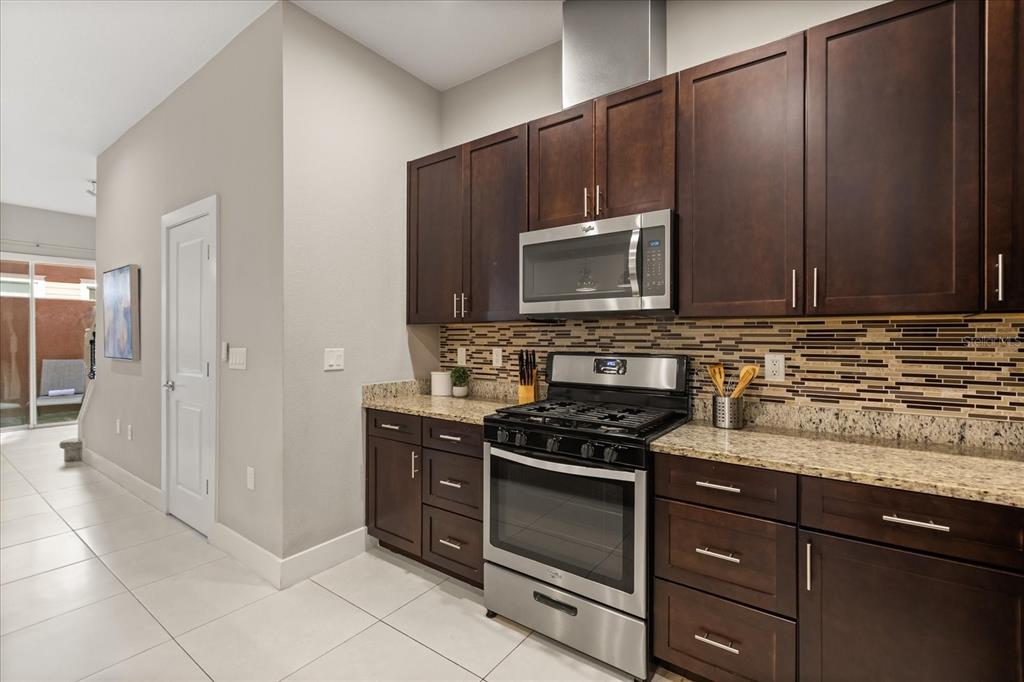 2637 Sunrise Shores Drive Kissimmee, FL 34747 - Photo 9 of 39 a kitchen with granite countertop wooden cabinets and stainless steel appliances