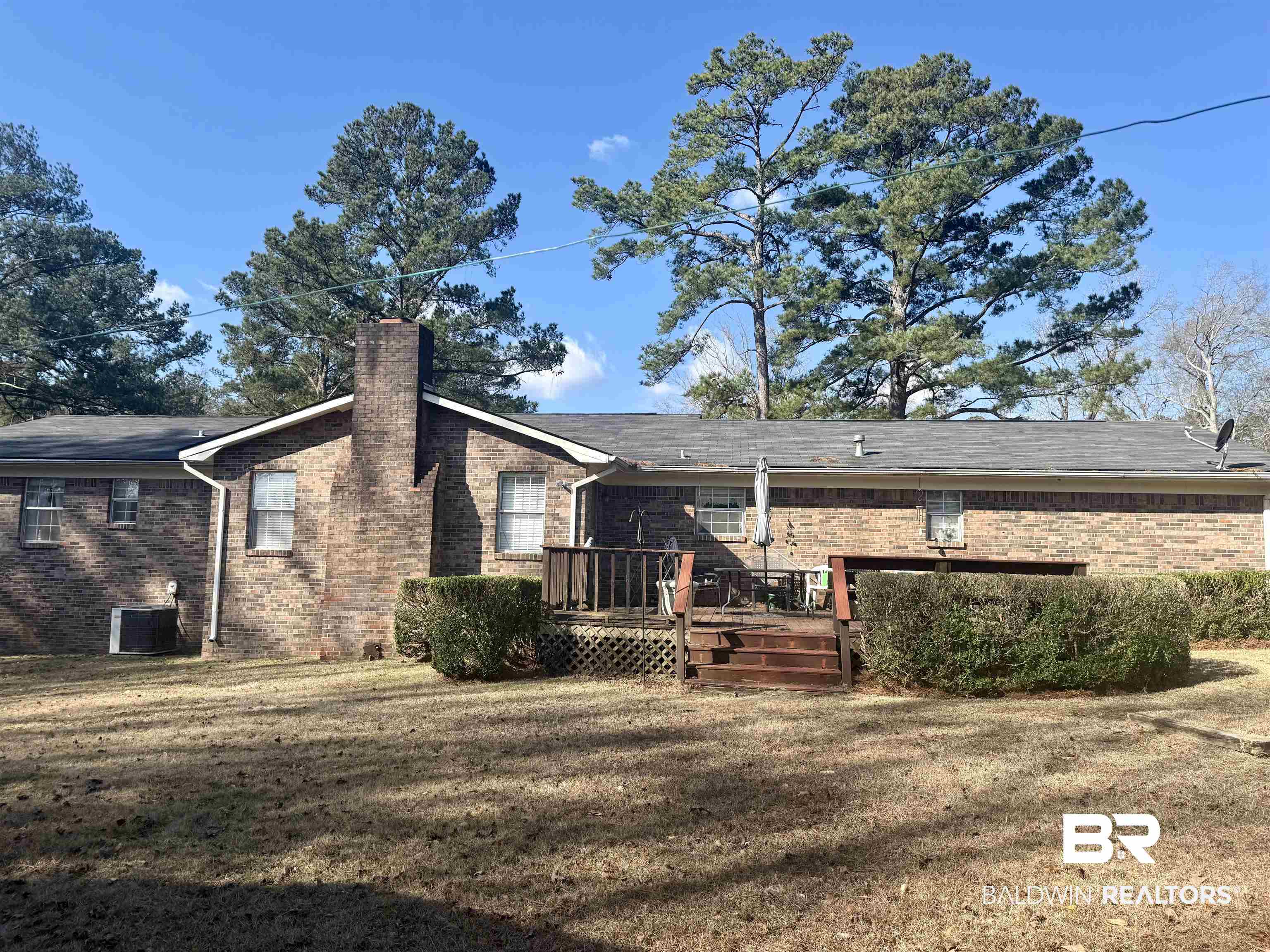 215 Young Street Brewton, AL 36426 - Photo 23 of 25 Rear view of house featuring a yard, a wooden deck, a chimney, and brick siding