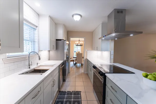 a large kitchen with granite countertop a sink and dishwasher a stove top oven with wooden floor