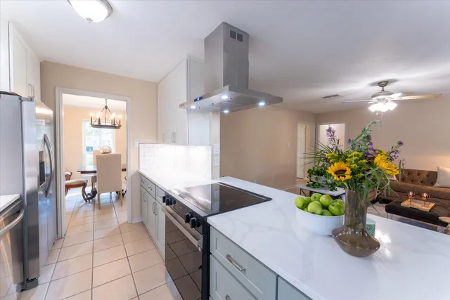 a kitchen with kitchen island a counter top space a sink stainless steel appliances and cabinets