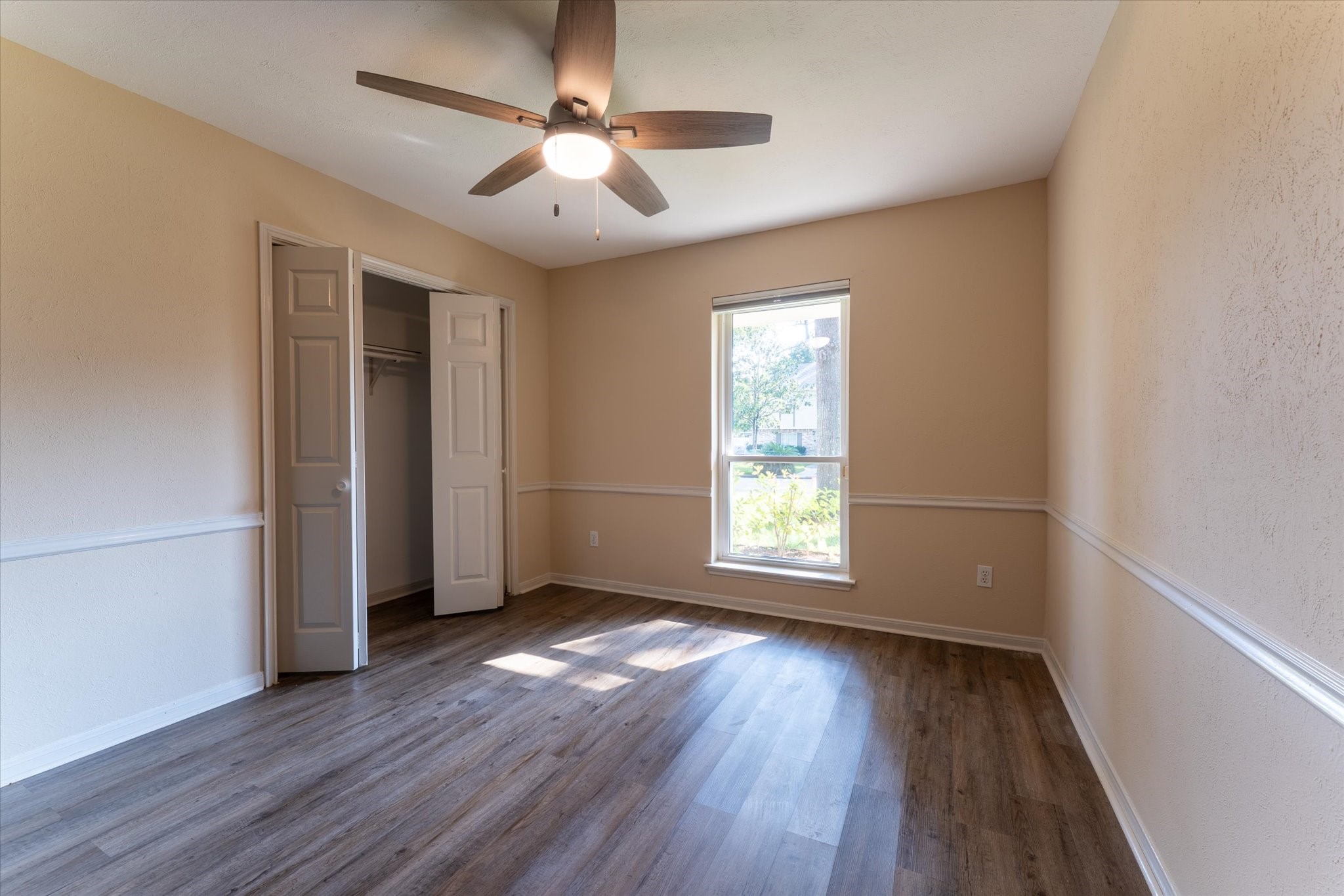 25019 Barmby Drive Spring, TX 77389 - Photo 28 of 43 an empty room with wooden floor chandelier fan and windows
