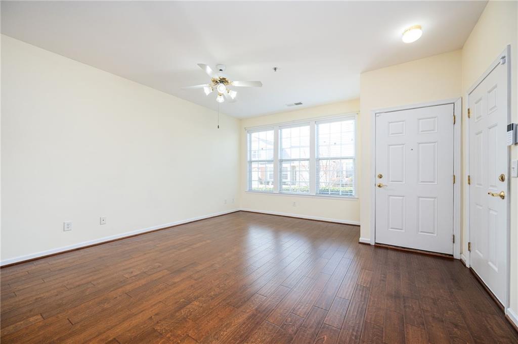248 Riverstone Place Canton, GA 30114 - Photo 12 of 29 an empty room with wooden floor chandelier fan and windows
