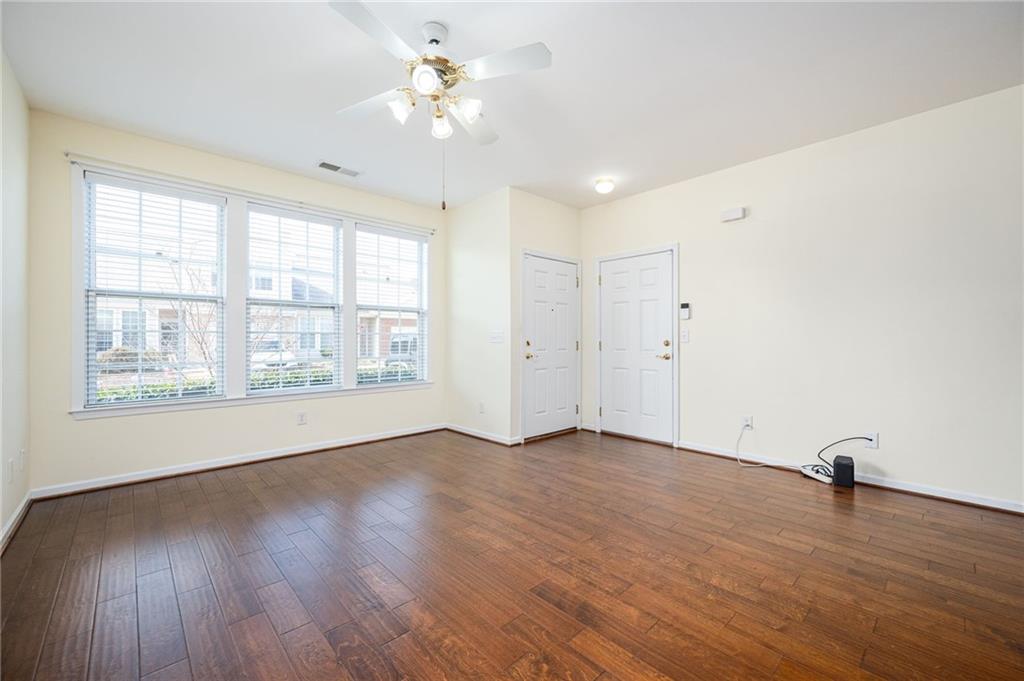 248 Riverstone Place Canton, GA 30114 - Photo 13 of 29 an empty room with wooden floor chandelier fan and windows
