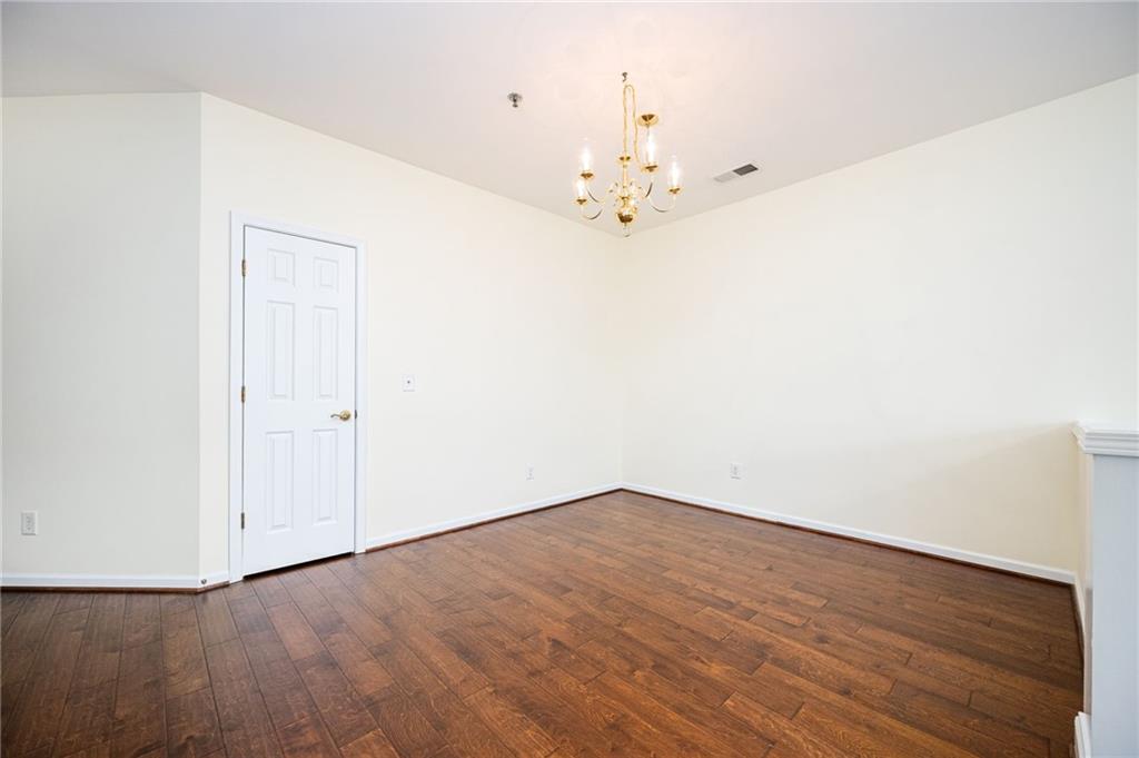 248 Riverstone Place Canton, GA 30114 - Photo 15 of 29 an empty room with wooden floor and chandelier fan