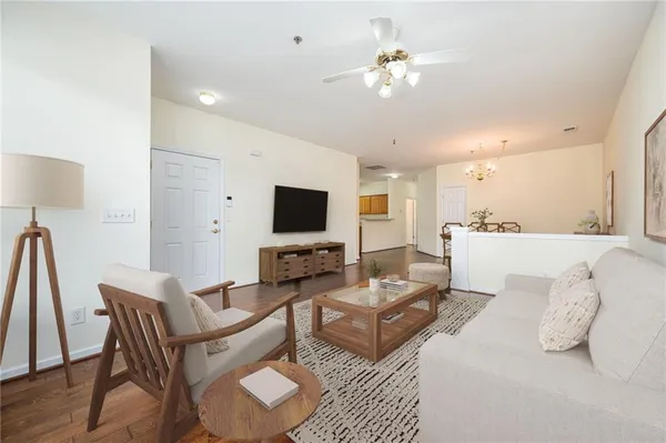 a living room with furniture a flat screen tv and kitchen view