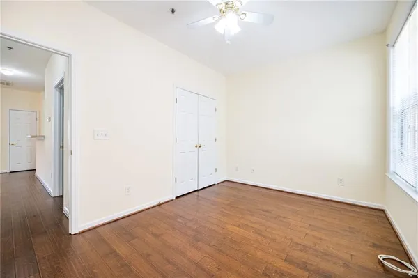 an empty room with wooden floor and windows