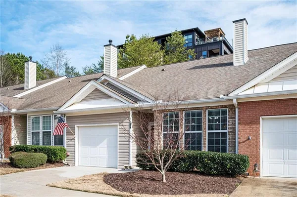 a front view of a house with a yard and potted plants