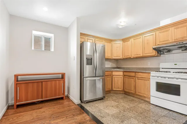 a kitchen with stainless steel appliances granite countertop a refrigerator sink and stove