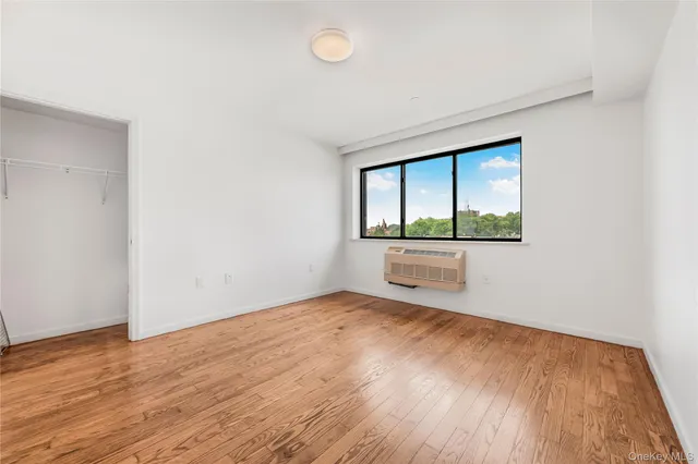 an empty room with a window and wooden floor