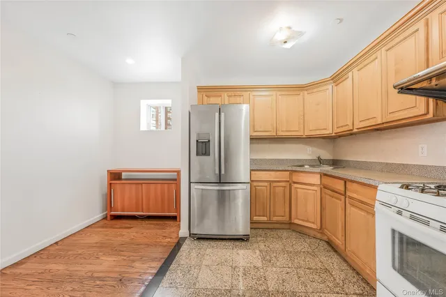 a kitchen with stainless steel appliances granite countertop a refrigerator sink and stove