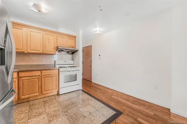 a kitchen with granite countertop white cabinets and white appliances