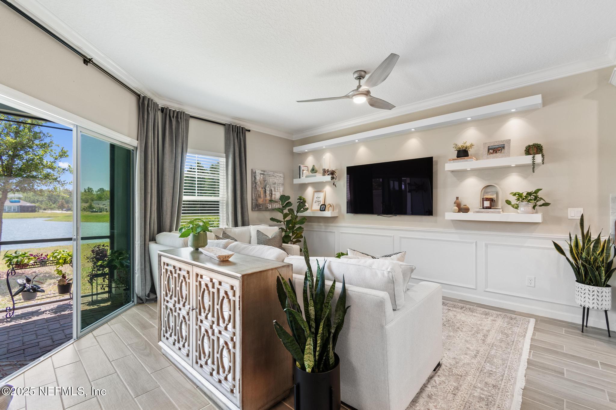 155 Appleton Court St. Augustine, FL 32092 - Photo 16 of 56 a living room with furniture a flat screen tv and a floor to ceiling window