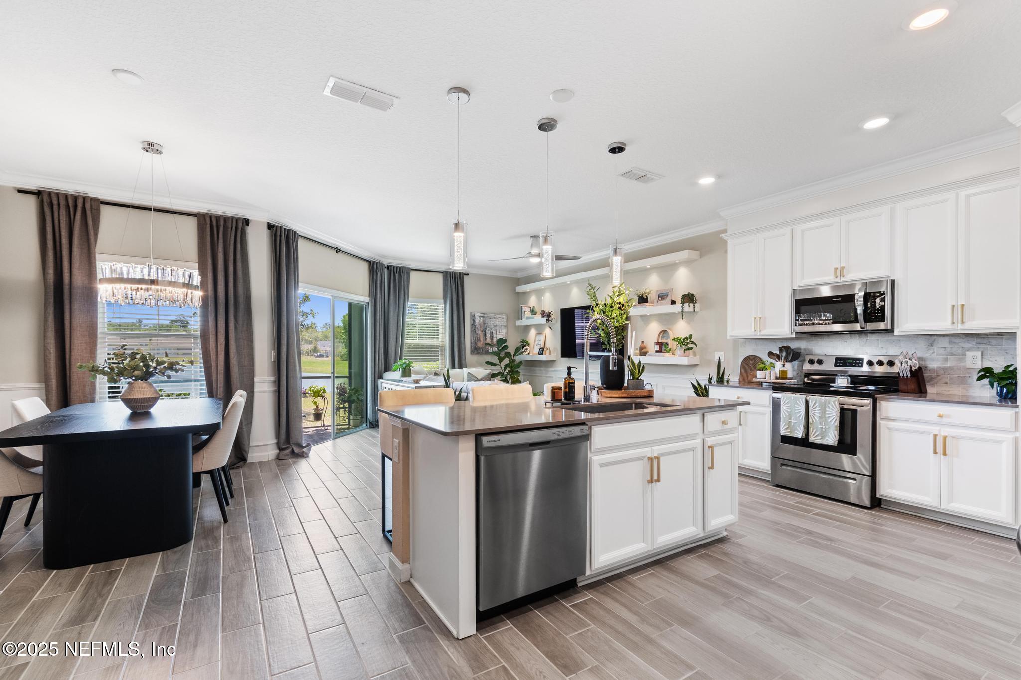 155 Appleton Court St. Augustine, FL 32092 - Photo 3 of 56 a kitchen with stainless steel appliances kitchen island granite countertop a stove and a sink