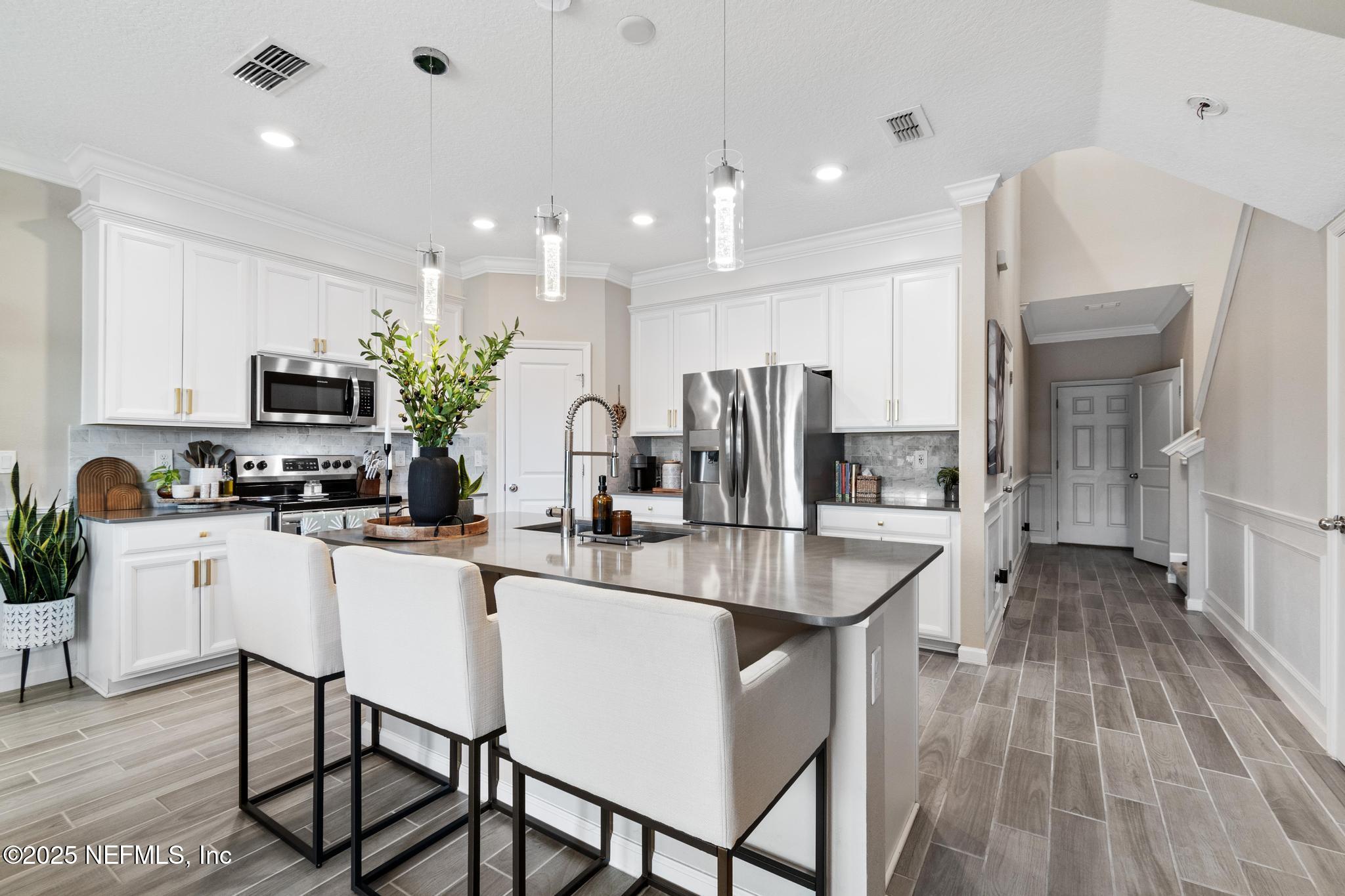 155 Appleton Court St. Augustine, FL 32092 - Photo 7 of 56 a kitchen with stainless steel appliances granite countertop a refrigerator a stove top oven a sink dishwasher and white cabinets with wooden floor
