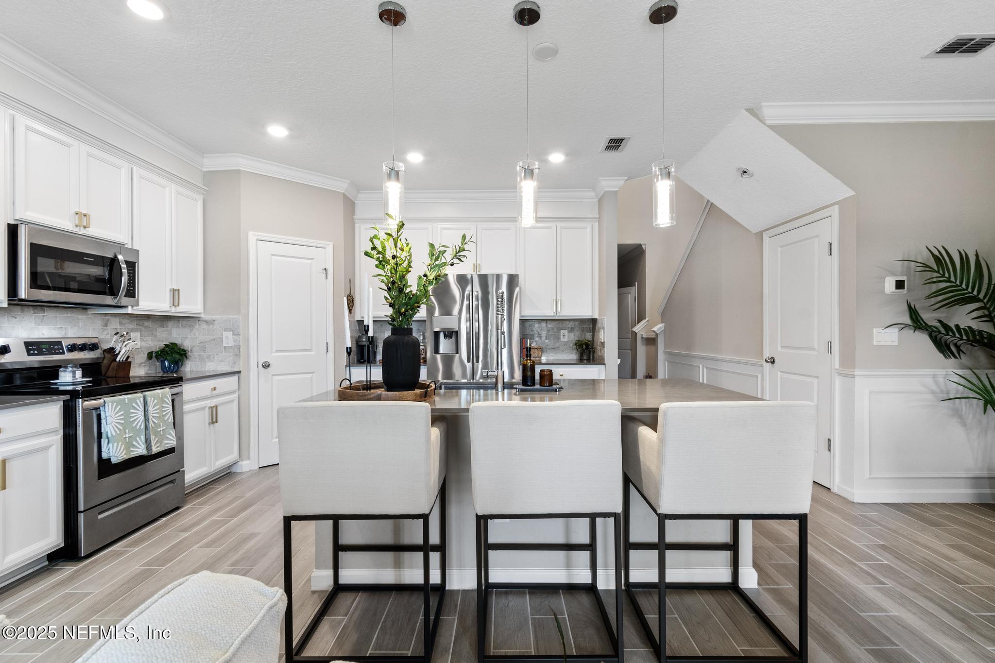 155 Appleton Court St. Augustine, FL 32092 - Photo 8 of 56 a kitchen with stainless steel appliances kitchen island granite countertop a stove a sink a dining table and chairs