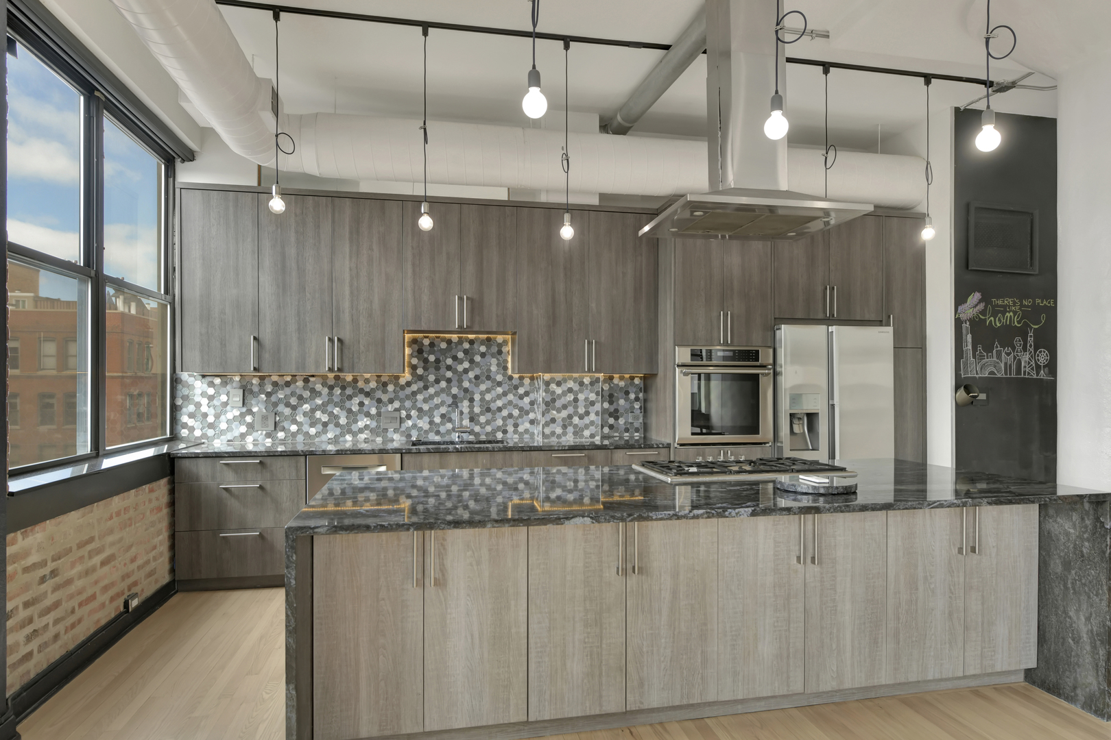 812 West Van Buren Street, Unit 5A Chicago, IL 60607 - Photo 7 of 26 a kitchen with kitchen island granite countertop counter top space and stainless steel appliances