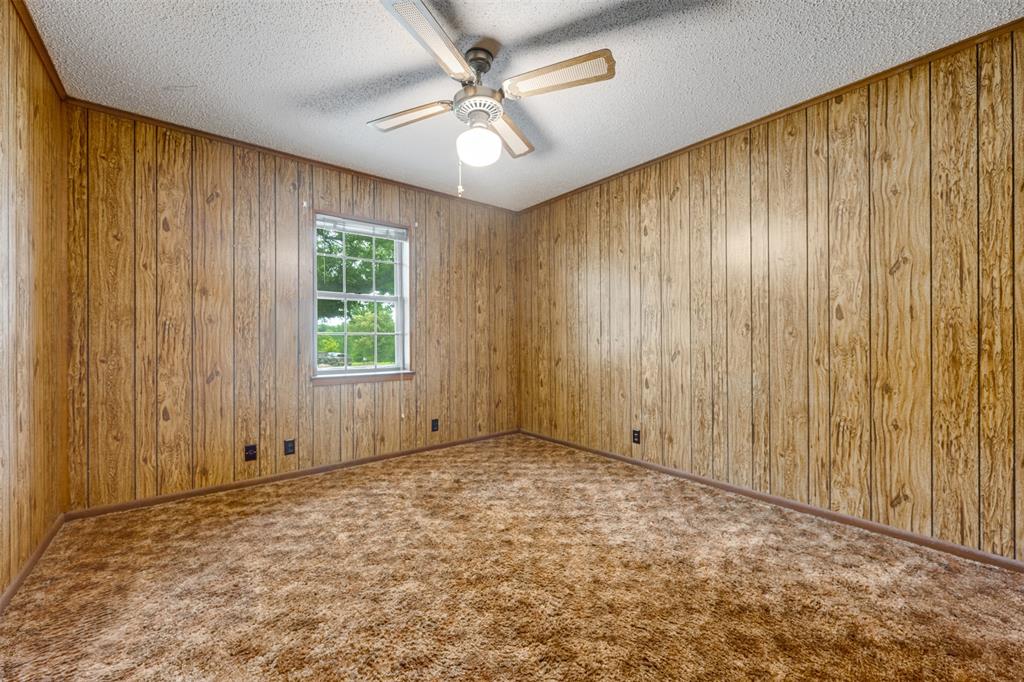 8798 Hill N Dale Road Tyler, TX 75709 - Photo 20 of 31 Room featuring wood-paneled walls, a single-pane window, and a ceiling fan with integrated lighting