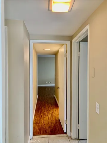 a view of a hallway with wooden floor and a living room