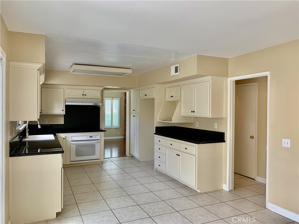 15 Butler Street Irvine, CA 92612 - Photo 8 of 37 a kitchen with granite countertop a sink a stove and refrigerator