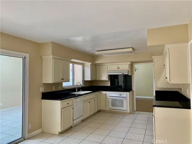 a kitchen with a sink a stove and cabinets
