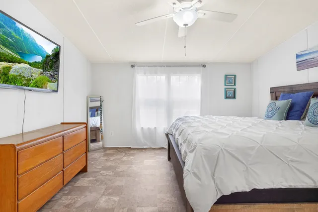 a spacious bedroom with a bed and a chandelier