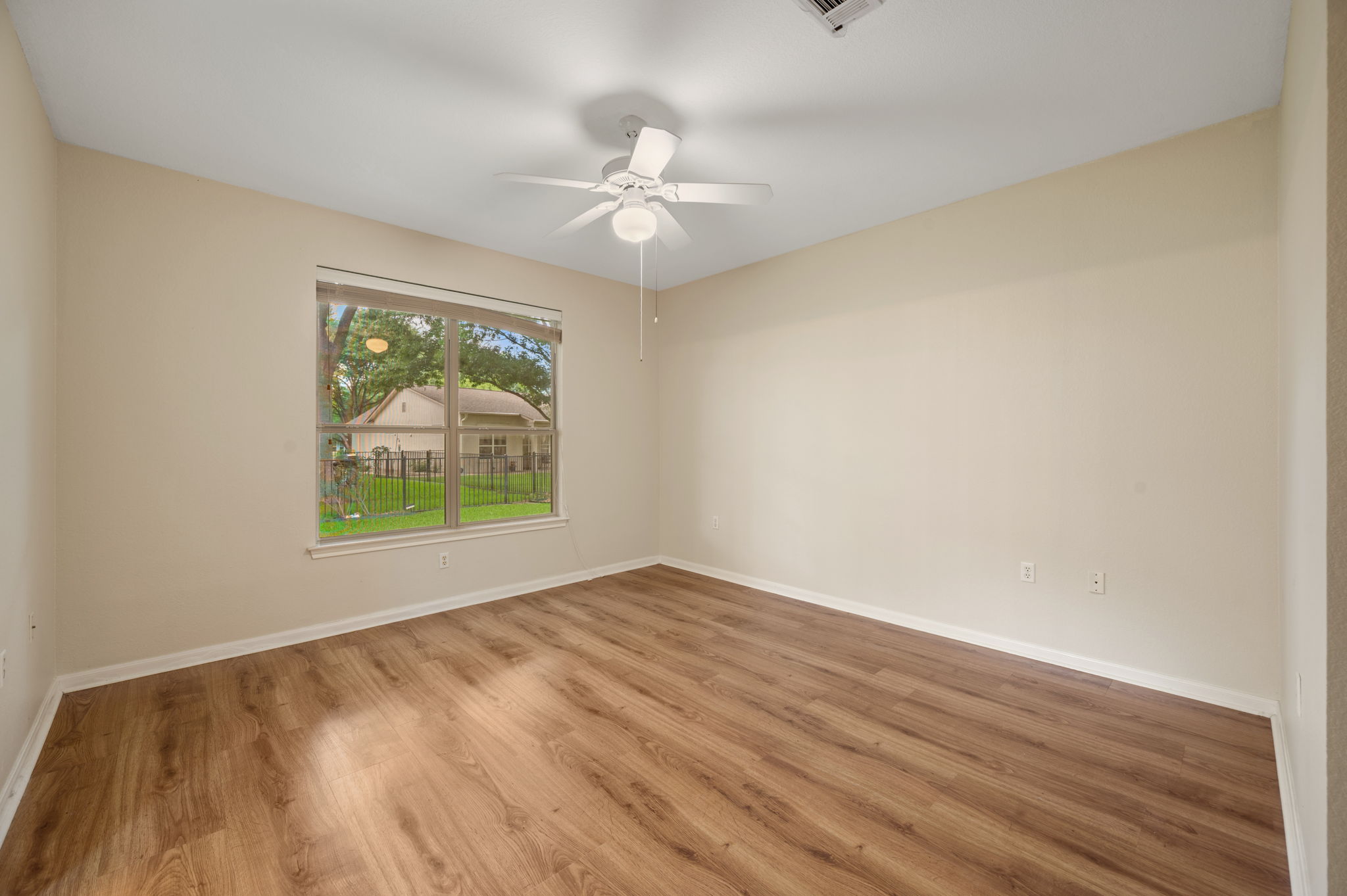 118 Bass Street Georgetown, TX 78633 - Photo 23 of 40 Well-lit living area with rich wood flooring and a refreshing ceiling fan.