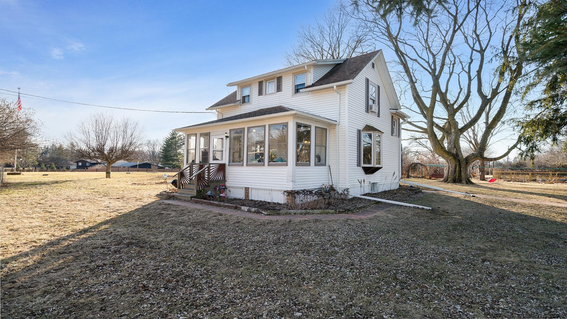 a front view of a house with a yard covered with snow