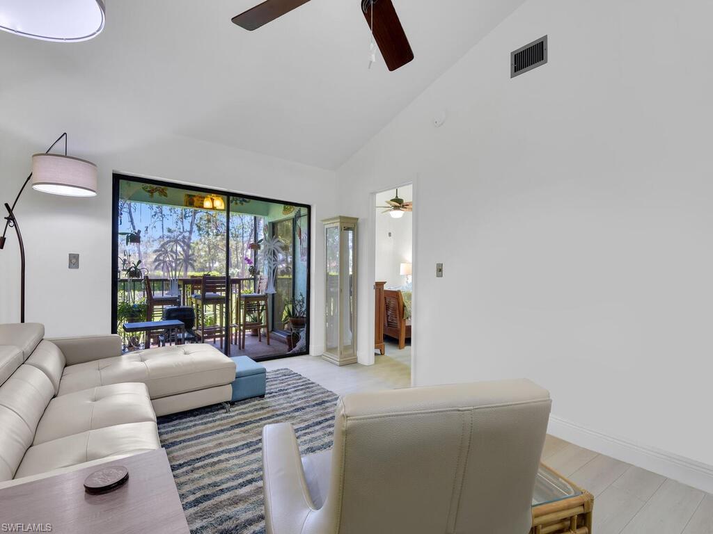 5825 Rattlesnake Hammock Road, Unit 202 Naples, FL 34113 - Photo 11 of 30 a living room with furniture and a large window