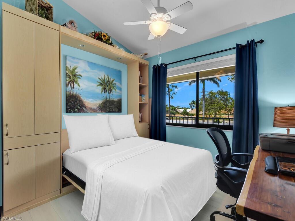 5825 Rattlesnake Hammock Road, Unit 202 Naples, FL 34113 - Photo 15 of 30 a bedroom with a large bed and a painting on the wall
