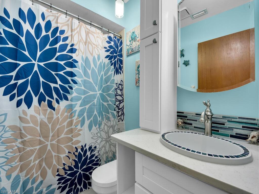 5825 Rattlesnake Hammock Road, Unit 202 Naples, FL 34113 - Photo 18 of 30 a bathroom with a sink and mirror with toilet